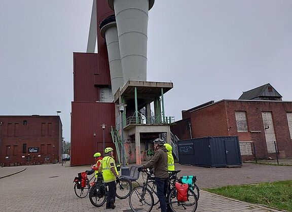 Radlergruppe vor den Diffusoren der Lüfteranlage am Schacht des früheren Steinkohlenbergwerks Schlägel und Eisen