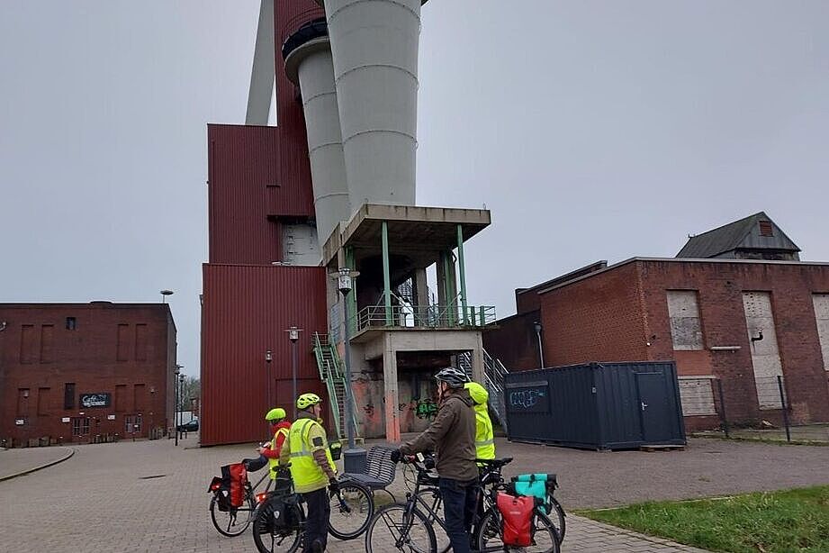 Radlergruppe vor den Diffusoren der Lüfteranlage am Schacht des früheren Steinkohlenbergwerks Schlägel und Eisen