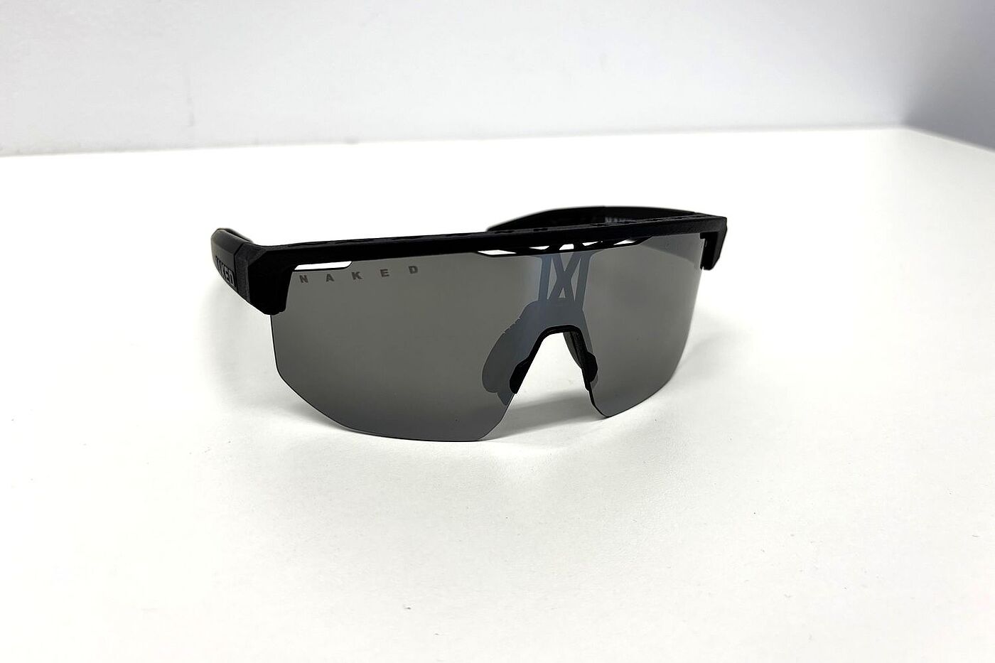 Shyft Front Eine Radbrille mit getönter Scheibe liegt auf einem weißen Tisch.
